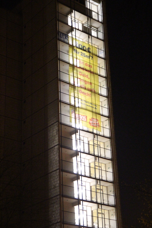 Gerokstraße 38 mit Banner mit der Aufschrift „Wenn das Land nicht zahlt, steigen Studis aufs Dach“ bei Nacht